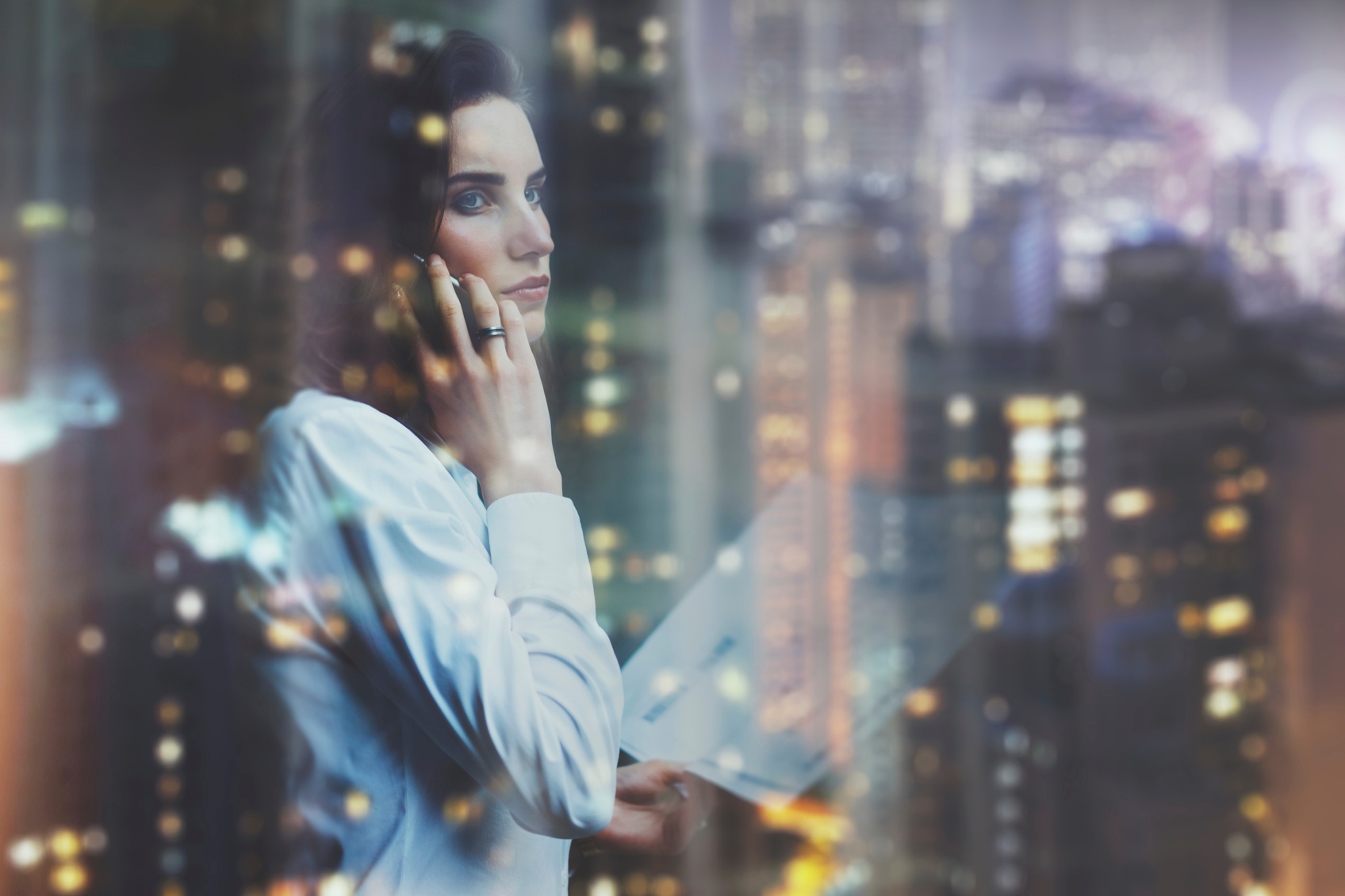 Photo-woman-wearing-white-shirt-talking-smartphone-and-holding-business-000089979727_Medium.jpg